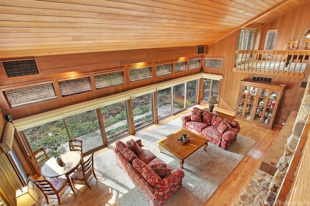 living room with vaulted ceiling, wooden walls, and wood ceiling