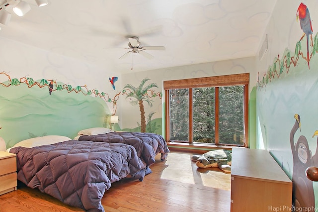 bedroom with light hardwood / wood-style flooring and ceiling fan