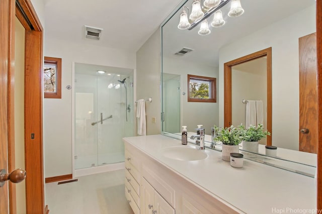 bathroom featuring large vanity and a shower with shower door