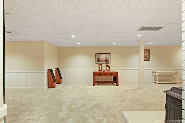 sitting room featuring light carpet and a drop ceiling