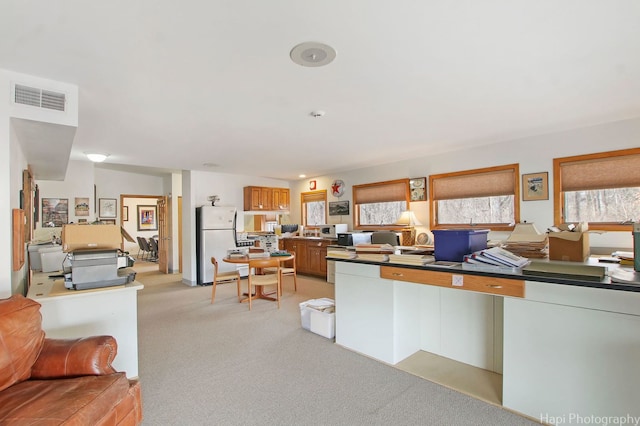 kitchen featuring white fridge and light carpet