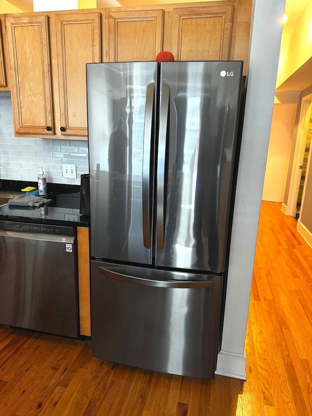 kitchen with hardwood / wood-style flooring, stainless steel appliances, and decorative backsplash