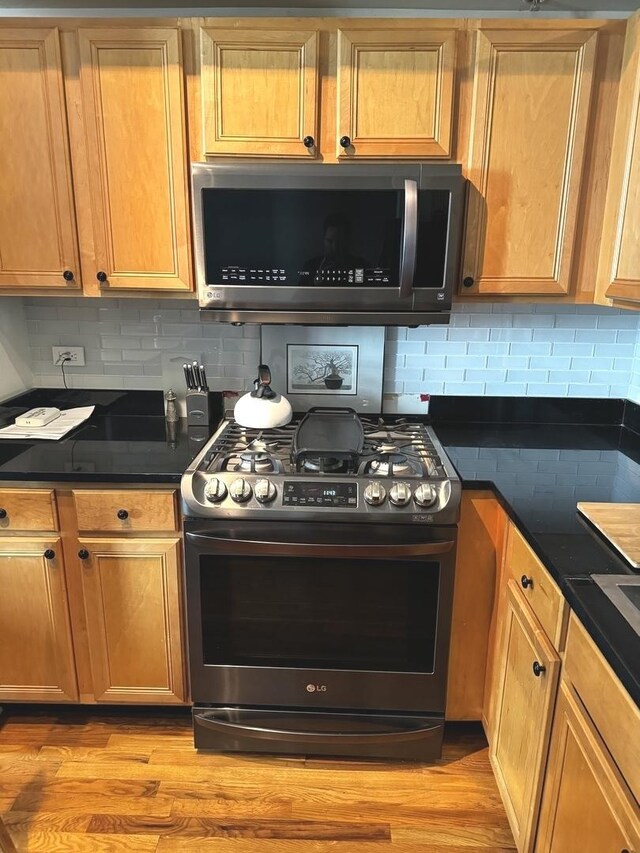 kitchen with light hardwood / wood-style floors, tasteful backsplash, and stainless steel appliances