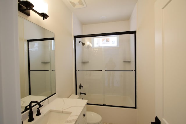 bathroom featuring combined bath / shower with glass door, toilet, vanity, and visible vents