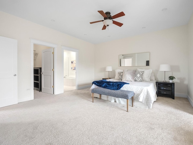 carpeted bedroom featuring ensuite bath, baseboards, and ceiling fan