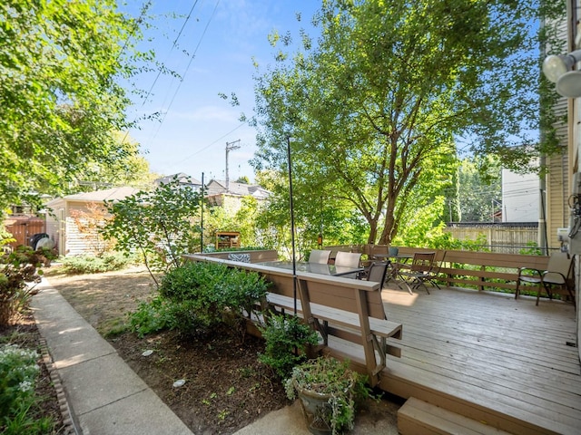 view of community featuring outdoor dining area and a wooden deck