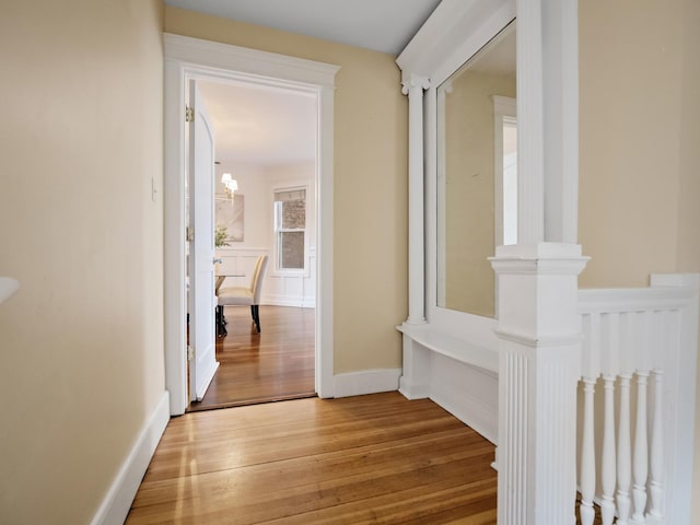 corridor with baseboards and wood finished floors