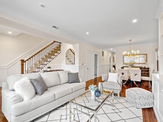 living area with a notable chandelier, stairway, wood finished floors, and recessed lighting