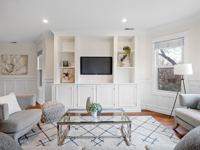 living room featuring visible vents, ornamental molding, wood finished floors, built in shelves, and recessed lighting