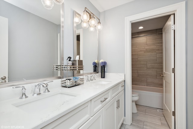 full bathroom with tiled shower / bath, toilet, tile floors, and dual vanity