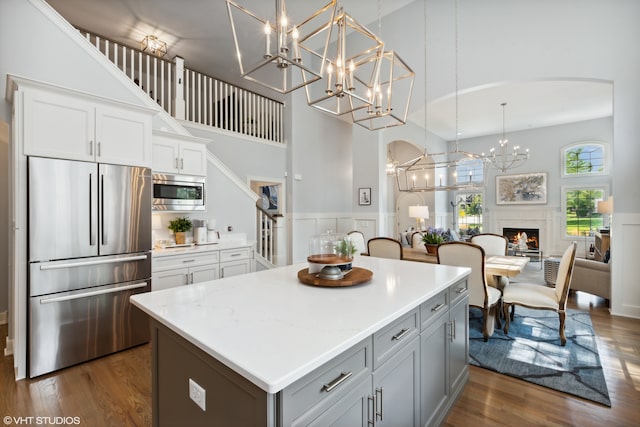 kitchen with built in appliances, dark hardwood / wood-style flooring, and a high ceiling