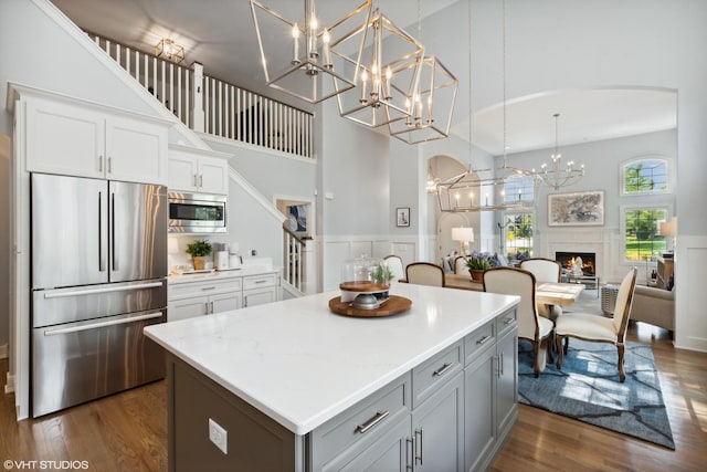 9748 Folkers Dr, Frankfort, IL 60423 - kitchen featuring stainless steel appliances, arched walkways, a towering ceiling, and an inviting chandelier