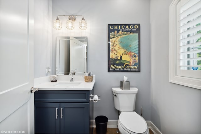 bathroom featuring vanity with extensive cabinet space and toilet