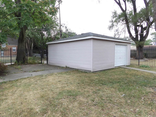 view of outdoor structure with a garage and a lawn