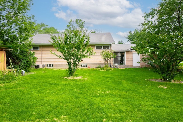 back of house featuring a yard and central AC