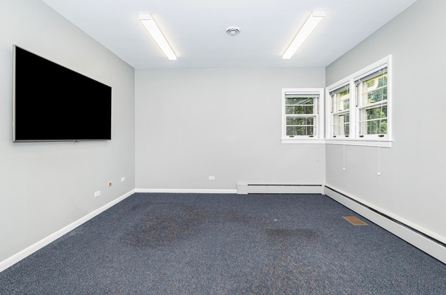 empty room with carpet flooring and a baseboard radiator