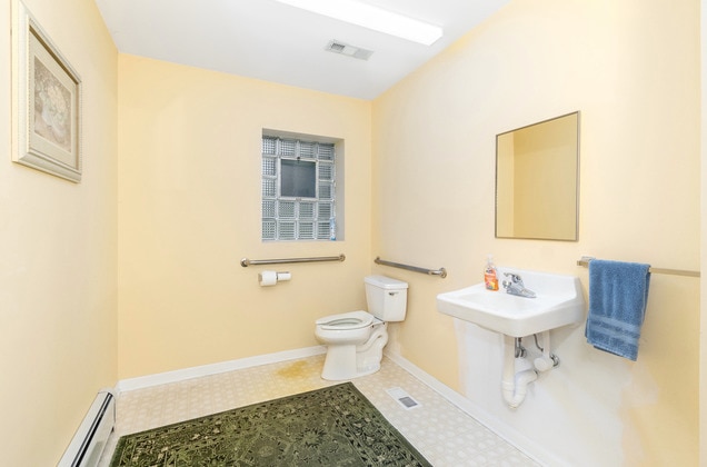 bathroom with baseboard heating, toilet, tile flooring, and sink