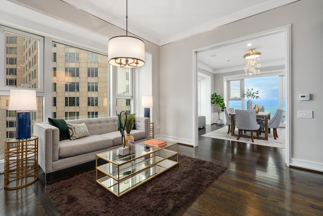 living room featuring dark wood-type flooring, ornamental molding, and a chandelier