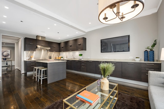 kitchen with tasteful backsplash, a breakfast bar area, dark brown cabinets, dark wood-type flooring, and a center island