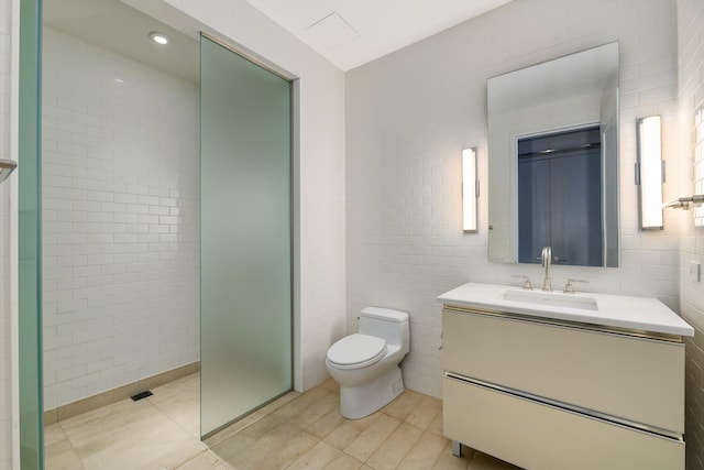 bathroom featuring walk in shower, tile walls, vanity, and toilet