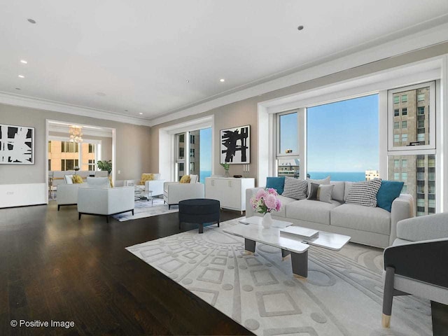 living room with an inviting chandelier, crown molding, and hardwood / wood-style flooring