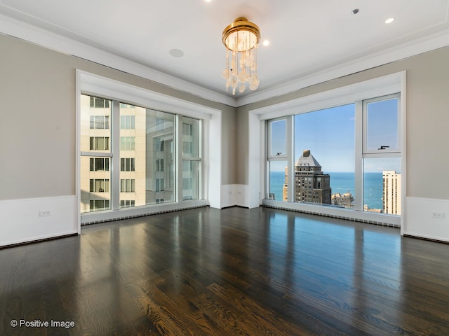 unfurnished room featuring ornamental molding, a water view, an inviting chandelier, and dark hardwood / wood-style floors