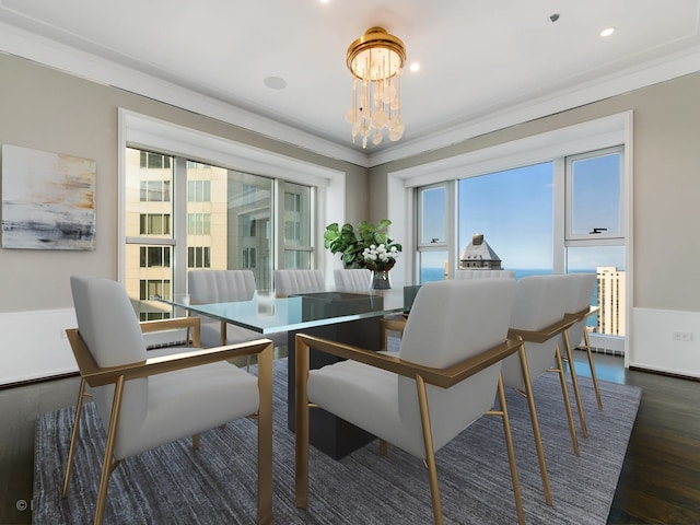 dining area featuring dark wood-type flooring, a chandelier, and ornamental molding