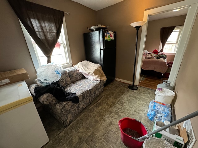 bedroom featuring black refrigerator and dark tile flooring