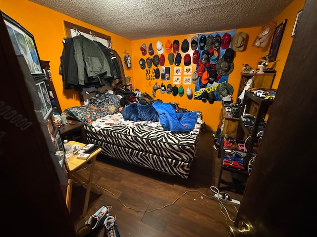 bedroom featuring hardwood / wood-style flooring and a textured ceiling