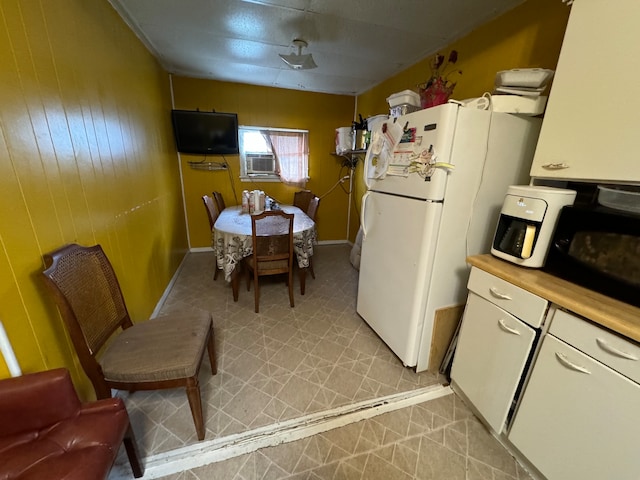 kitchen featuring white refrigerator and light tile floors