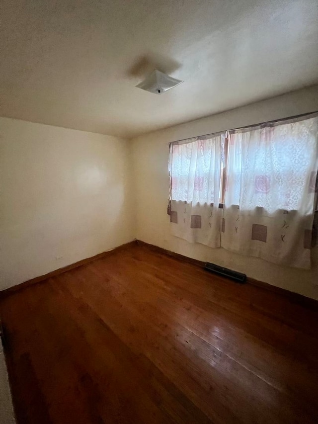 empty room with hardwood / wood-style flooring