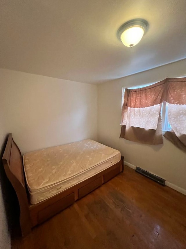 bedroom with dark hardwood / wood-style floors