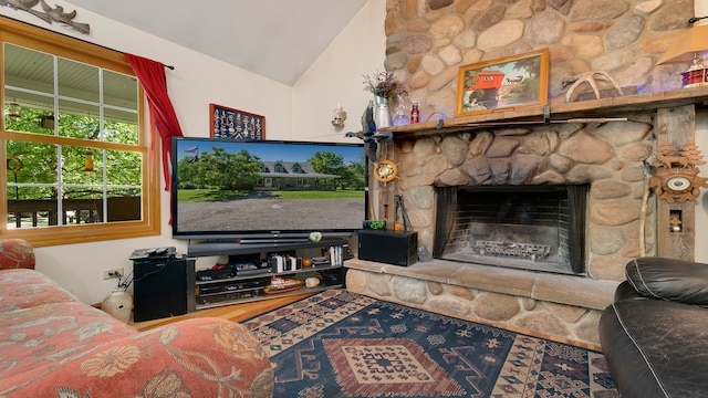 living room with a stone fireplace, wood-type flooring, and vaulted ceiling