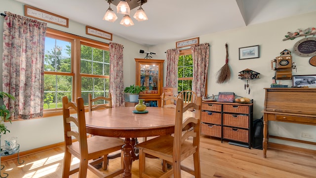 dining room featuring a wealth of natural light, light hardwood / wood-style floors, and a notable chandelier