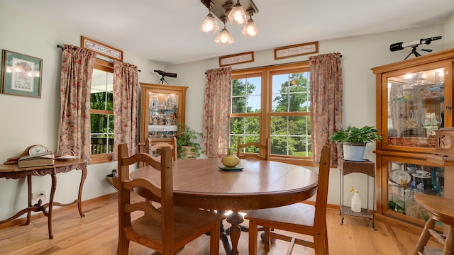 dining area featuring light hardwood / wood-style floors and an inviting chandelier