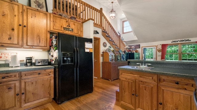 kitchen featuring a healthy amount of sunlight, wood-type flooring, sink, and black refrigerator with ice dispenser