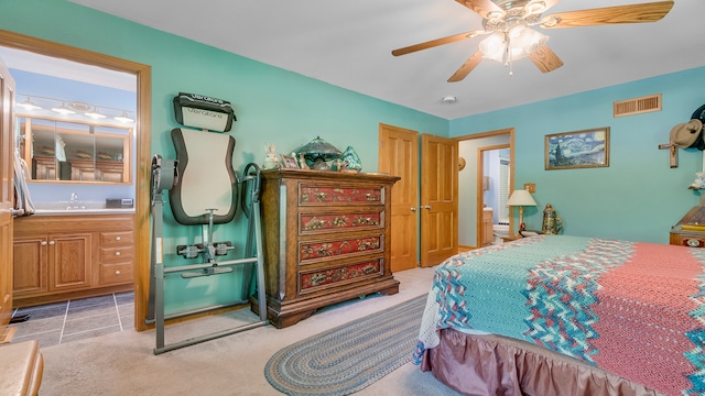 carpeted bedroom with ensuite bath, ceiling fan, and sink