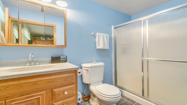 bathroom with tile patterned flooring, vanity, toilet, and walk in shower