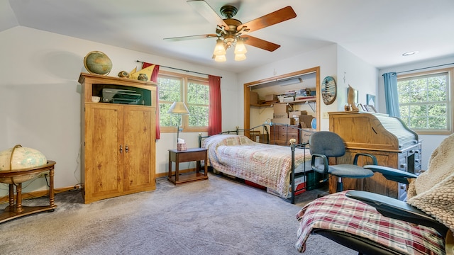 carpeted bedroom featuring multiple windows, vaulted ceiling, and ceiling fan