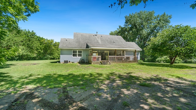 rear view of property with covered porch and a yard