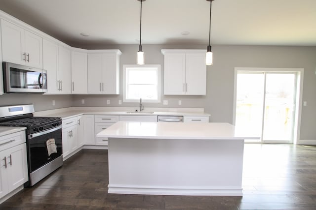 kitchen with appliances with stainless steel finishes, dark wood-type flooring, and white cabinetry