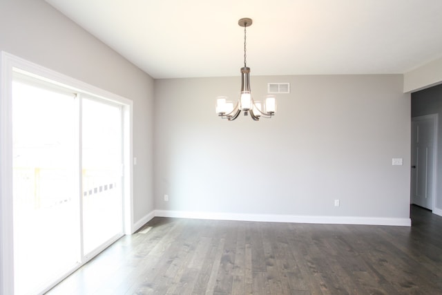 spare room with hardwood / wood-style floors and a chandelier