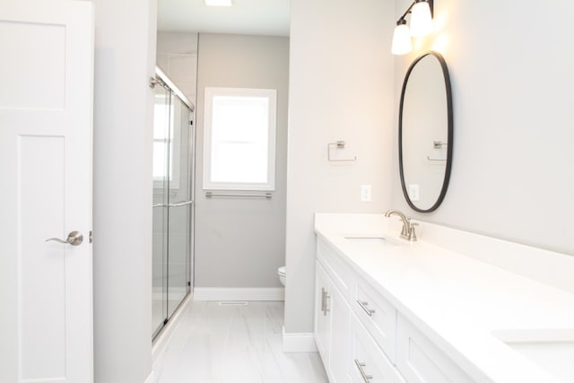 bathroom with a shower with door, oversized vanity, toilet, double sink, and tile floors