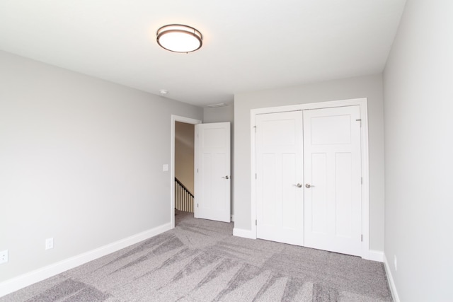 unfurnished bedroom featuring carpet flooring and a closet