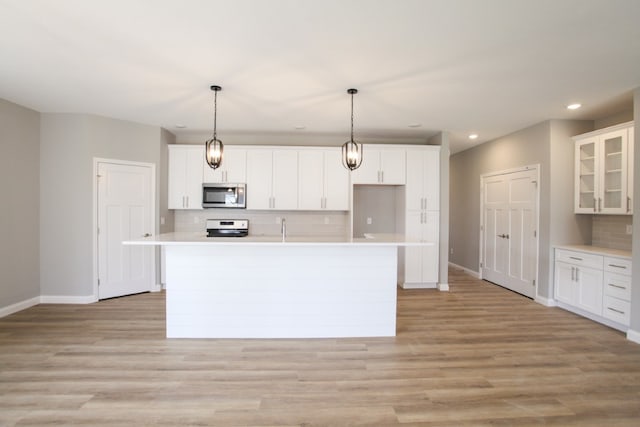 kitchen featuring white cabinets, tasteful backsplash, and light wood-type flooring