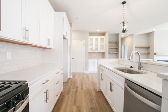 kitchen with light hardwood / wood-style floors, tasteful backsplash, white cabinetry, sink, and stainless steel dishwasher