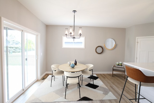 dining space with a notable chandelier and light hardwood / wood-style floors