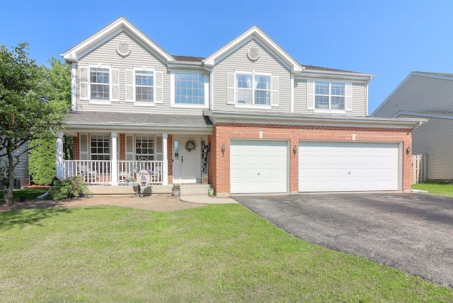 11 N Berkshire Ln, Round Lake, IL 60073 - view of front facade featuring covered porch, driveway, an attached garage, a front yard, and brick siding