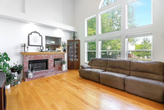 11 N Berkshire Ln, Round Lake, IL 60073 - living area with a towering ceiling, wood finished floors, and a brick fireplace