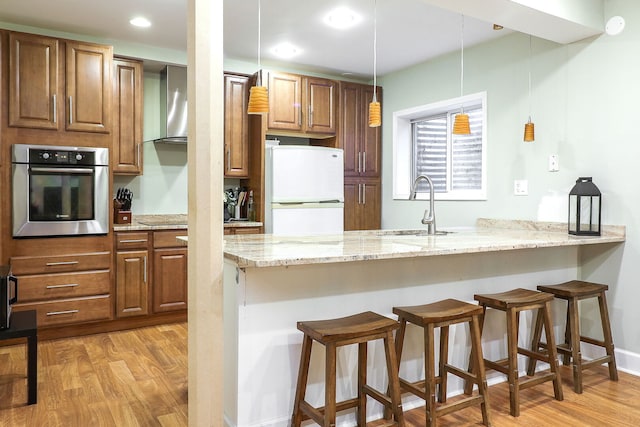 11 N Berkshire Ln, Round Lake, IL 60073 - kitchen with stainless steel oven, freestanding refrigerator, wall chimney exhaust hood, a breakfast bar, and recessed lighting